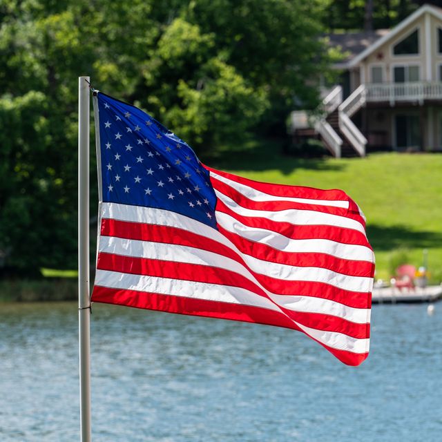 American flag beside a lakeside home